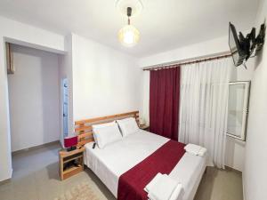 a bedroom with a large bed with a red curtain at Hotel Restaurant Ujimira in Radomirë