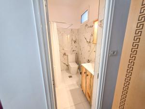 a bathroom with a toilet and a sink at Hotel Restaurant Ujimira in Radomirë