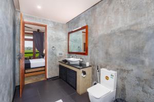 a bathroom with a toilet and a sink and a mirror at Ceylon Breeze Sigiriya in Sigiriya +87 photos