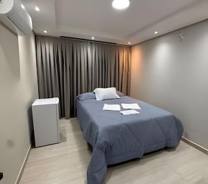 a bedroom with a bed in a room with curtains at Maryah Prime Studio Hotel Extrema + breakfast in Extrema