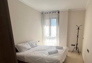 a white bed in a room with a window at B2 Apartment 4 in Kashari