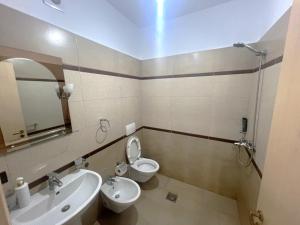 a bathroom with a sink and a toilet and a mirror at B2 Apartment 4 in Kashari