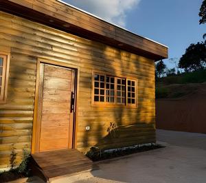 a wooden building with a door and a window at Maryah Prime Studio Hotel Extrema + breakfast in Extrema