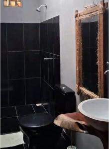 a bathroom with a black toilet and a sink at Bicho Grilo Hostel in Atins +30 photos