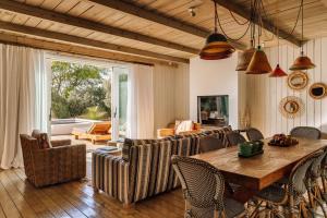 a living room with a wooden table and chairs at Quinta Da Comporta - Wellness Boutique Resort in Comporta