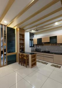 a large kitchen with a table in the middle at Luxury private pool villa for families & groups in Ujjain +9 photos