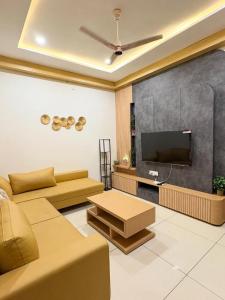 a living room with a couch and a flat screen tv at Luxury private pool villa for families & groups in Ujjain