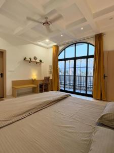 a large bedroom with a large bed and a desk at Luxury private pool villa for families & groups in Ujjain