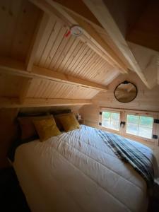 a bed in a room with a wooden ceiling at Cozy Woodland Bunkie Outdoor Shower WiFi in Simcoe