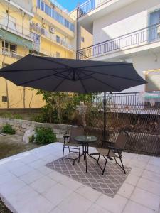 a table and two chairs under a black umbrella at Konstantinos Loft in Serres