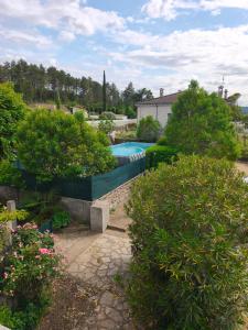 a backyard with a swimming pool and some bushes at L oxygène ardéchois gîte 3 in Ruoms
