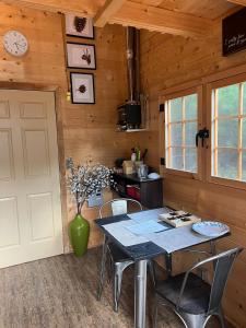 a dining room with a table and chairs and a clock at Cozy Woodland Bunkie Outdoor Shower WiFi in Simcoe