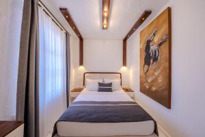 a small bedroom with a bed and a large window at B House Alaçatı in Alaçatı +66 photos