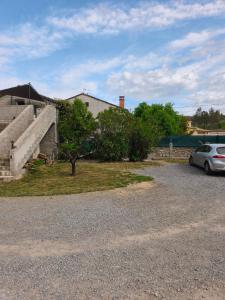 a car parked in a gravel lot next to a house at L oxygène ardéchois gîte 3 in Ruoms