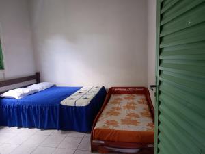 a small bedroom with a bed and a green door at Aluguel de Quarto em uma casa in Cavalcante +2 photos