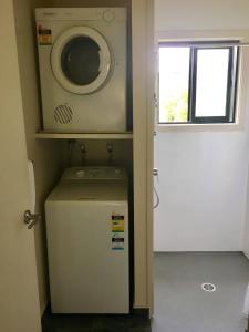 uma máquina de lavar roupa em cima de um pequeno frigorífico em Bay Road Motels em Haast