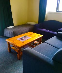 a living room with two couches and a coffee table at Bay Road Motels in Haast