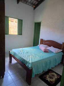 a bedroom with a bed in a room with two windows at Aluguel de Quarto em uma casa in Cavalcante
