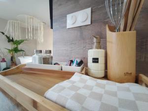 a room with a bed and a counter with a bottle of soap at La Suite Bohème Émeraude in Évreux