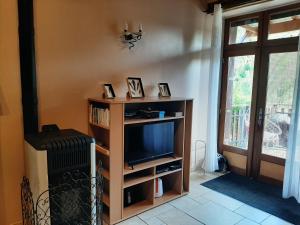 a living room with a tv and a radiator at gîte de Véreuges in Saint-Julien-des-Chazes