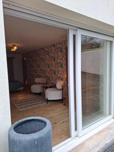 a sliding glass door with a table and chairs at La parenthèse in Puy-dʼArnac