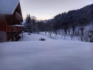 a yard covered in snow next to a house at Le Bochate in La Celle-sous-Gouzon