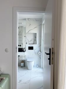 a bathroom with white marble walls and a toilet at powiew - b&b pensjonat noclegi Świnoujście - Unterkunft Swinemünde - guesthouse tennis garden breakfast at baltic sea in Świnoujście +40 photos