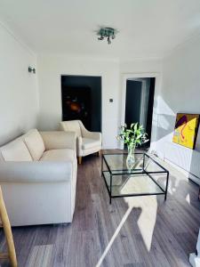 a living room with a white couch and a glass table at Palm Valley Villa in Poole