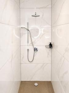 a bathroom with a shower with white tiles at Le Cocon Galhausen in Saint-Vith