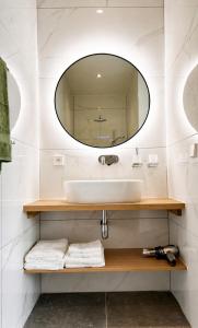 a bathroom with a sink and a mirror at Le Cocon Galhausen in Saint-Vith