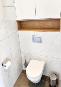 a white bathroom with a toilet and a sink at Le Cocon Galhausen in Saint-Vith