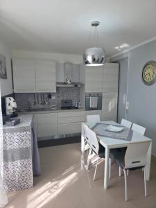 a kitchen with white cabinets and a table and chairs at Casa Quattro Cannelli in Pozzuoli +29 photos