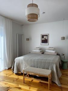 a white bedroom with a large bed and a bench at powiew - b&b pensjonat noclegi Świnoujście - Unterkunft Swinemünde - guesthouse tennis garden breakfast at baltic sea in Świnoujście