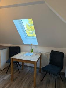 a table and two chairs in a room with a window at Wohnung Epprechtstein Seeperle Weißenstadt in Weißenstadt