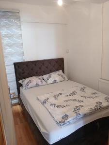 a bed in a small room with a bedspread and pillows at Apartman Danica in Foča
