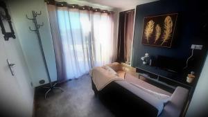 a living room with a bed and a television at LIntemporel in Saint-Sornin