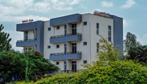 a white building with trees in front of it at Mamush Hotel in Ārba Minchʼ