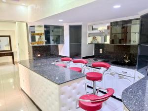 a large kitchen with red stools at a counter at Nile sky hotel and suites in Cairo