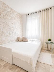 a white bedroom with a large bed and a window at Spacious Apartment with Garden & Terrace in Puerto de Santiago +28 photos