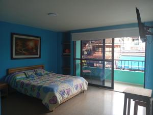 a bedroom with a bed and a view of a balcony at Hotel la perla del pereira in Rionegro