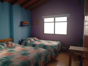 a bedroom with two beds and a window at Hotel la perla del pereira in Rionegro