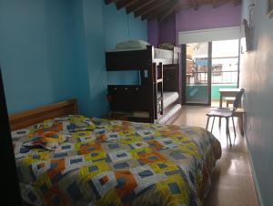 a bedroom with a bed with a colorful quilt at Hotel la perla del pereira in Rionegro
