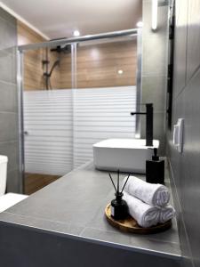 a bathroom with a sink and a shower with towels at The Lithos Loft Kyma in Ayía Marína +34 photos