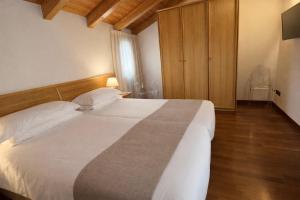 a bedroom with a large white bed and a chair at Residence Alle Palme in Riva del Garda +47 photos
