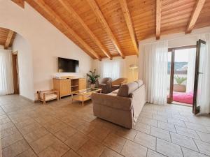 a living room with a couch and a tv at Residence Alle Palme in Riva del Garda