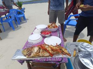a table with a tray of food on the beach at Funzi Beach Resturant in Funzi