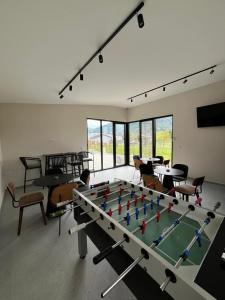 a ping pong table in a room with chairs at Conty in Vršac