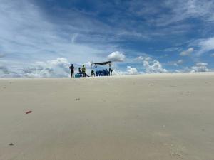 a group of people standing on top of a beach at Funzi Beach Resturant in Funzi
