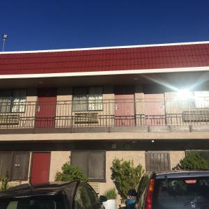 a building with red doors and a balcony at Crown Lodge Motel in Oakland