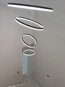 a trio of circular lights hanging from a white wall at Hermoso apartamento in Soledad